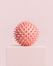 Balle de massage rose à picots sur socle rose pastel