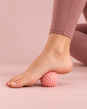 Utilisation de la balle de massage rose sous la voûte plantaire