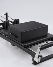 Illustration de la box Pilates noire posée sur le chariot d’un reformer