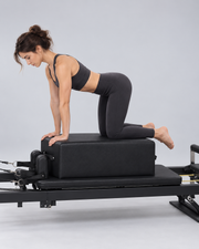 Illustration d’utilisation de la box Pilates noire sur un reformer