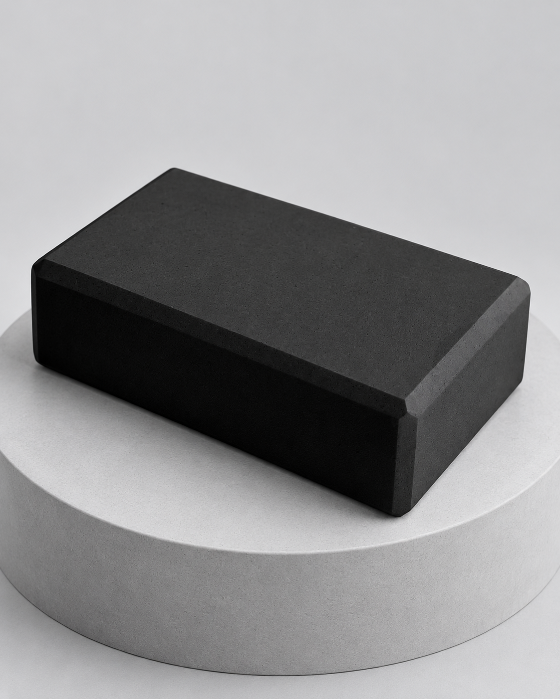 Brique de yoga en mousse noire sur socle gris