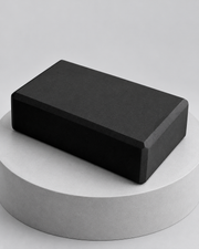 Brique de yoga en mousse noire sur socle gris