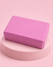 Brique de yoga en mousse rose sur socle rose