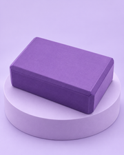 Brique de yoga en mousse violette sur socle lavande