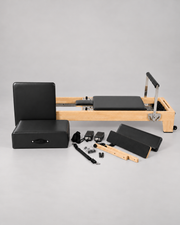 Reformer Pilates en bois fixe et accessoires présentés sur la photo du modèle