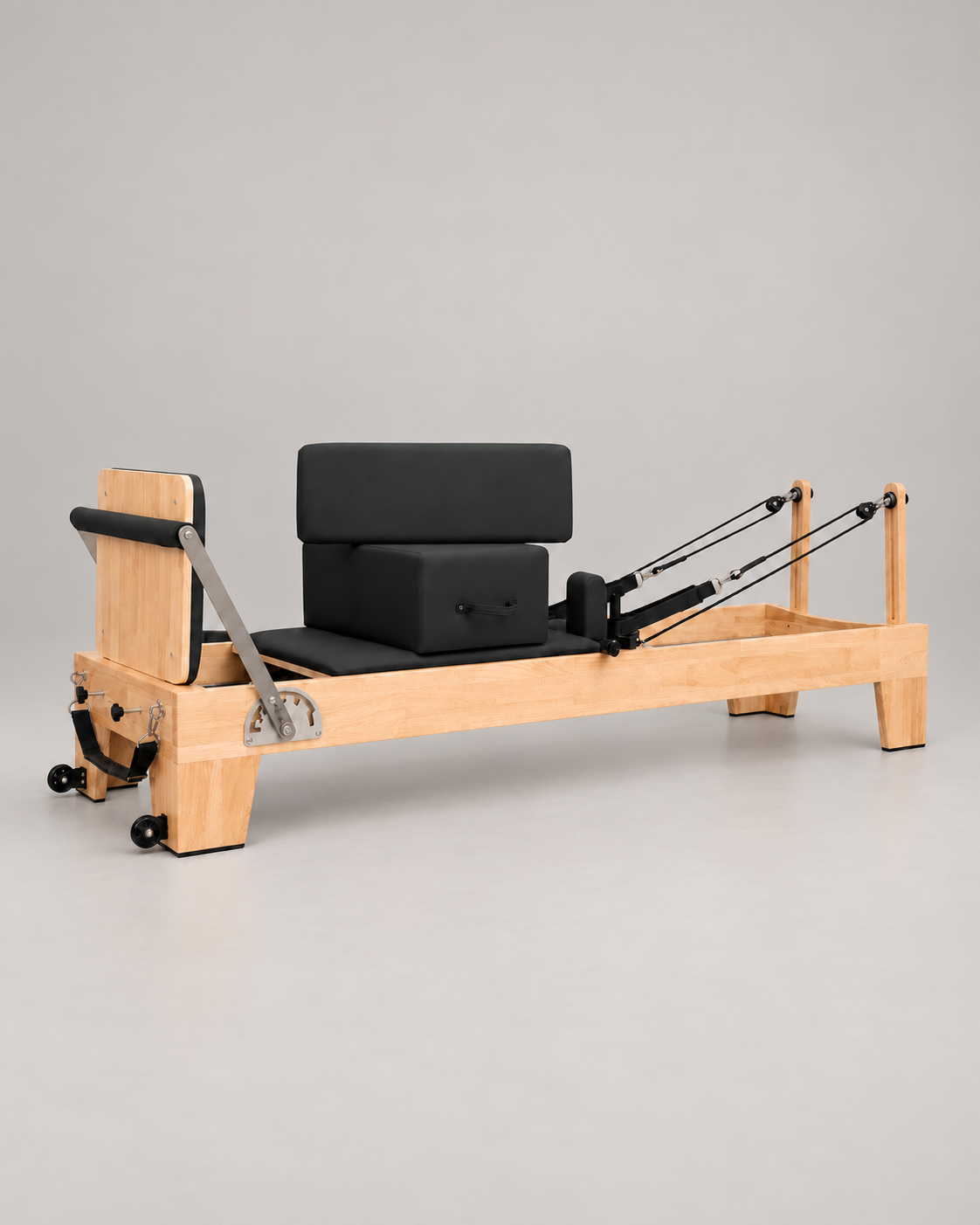 Reformer Pilates en bois fixe avec sellerie noire, vue d’ensemble