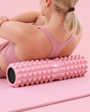 Rouleau de massage Pilates rose utilisé sous le haut du dos